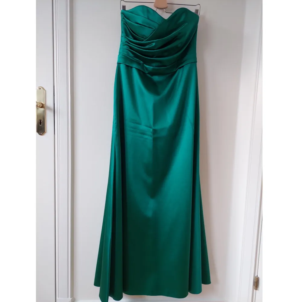 Klassisk axelbandslös balklänning i vacker grön färg, endast använd en gång! Passar perfekt i längd till mig som är 175 (se bild) Mått under byst 84 cm (diameter), mått överst 88 cm (insydd ca 6 cm överst). Klänningar.