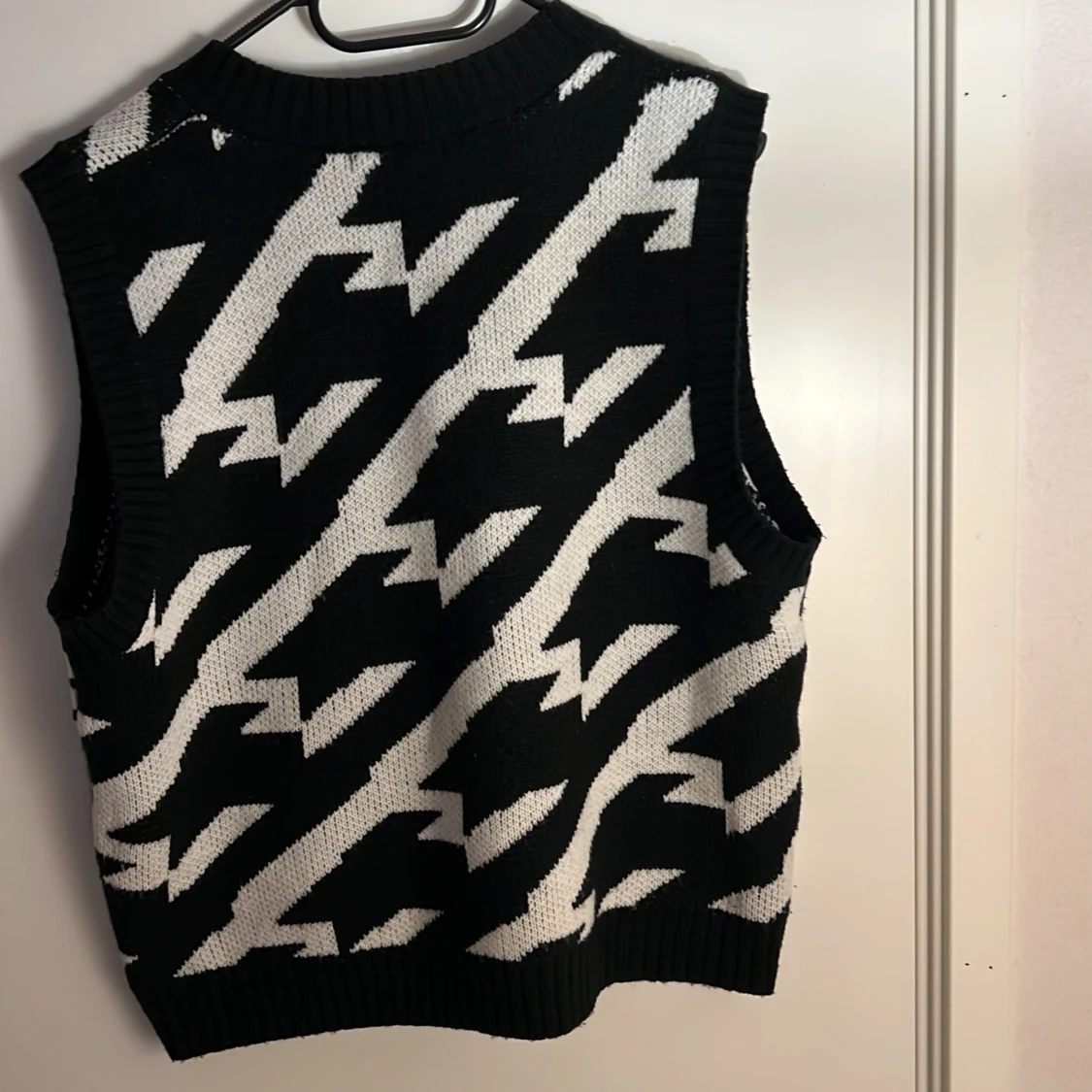 En stickad tröja som är randig svart och vit  - 92