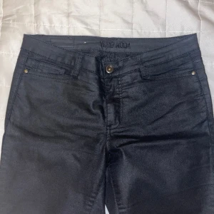 Glansiga byxor  - Svarta glansiga byxor från vero Moda i storlek L/32