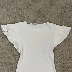 T-shorts med volanger  - Söt topp med volanger, inga fläckar eller skador. Sällan använd!