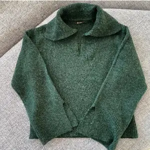 Grön stickad tröja från Gina Tricot. Köpt för 400:- använd en gång säljes pga för stor för mig. Snygg krage, långa vida ärmar med slits. Skick 10/10.