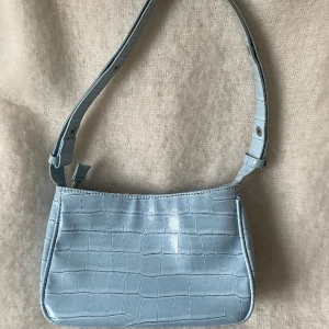 Baguettväska unlimit  - Baguettväska i blått läder från Unlimit bags. Sparsamt använd och i väldigt fint skick. Slutsåld och tillverkas inte längre, nypris cirka 700kr. Sista bilden är lånad. 