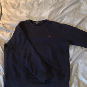 Polo Ralph Lauren Sweatshirt Mörkblå 160 - Tjena, säljer min Polo tröja. Den har använts mycket men har inga större tecken på användning, väl omhändertagen. Storleken är 160 vilket motsvarar XS. Skulle säga att den passar från 150-170 cm. Jag kunde ha den tills jag var 171 cm utan problem. 