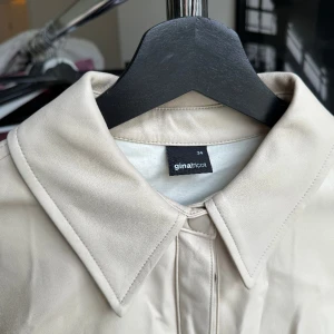 "Skinn" overshirt  - Nytvättad därför skrynklig. Använd en gång på lagfest. Från Gina. Trivs ej i färgen därför jag säljer.