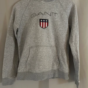 Gant hoodie - Grå gant hoodie, köpt från kidsbrandstore och är i jättebra skick. Säljer då den inte kommer till användning längre💗 köpt för 899kr!