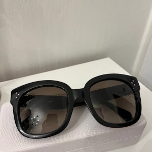 Celine new audrey solglasögon  - Svarta med brunt glas Äkta Celine glasögon   Har inte sparat boxen till tyvärr  Använda med slav på ramen och glaset (se bilder) fullt användbara och inget som syns tydligt på.   Nypris: 4300:-  Kontakta mig om ni har frågor:)