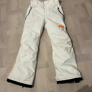 HH skidbyxor vita - Ett par vita Helly Hansen skidbyxor  Super sköna och varma och ett bra skidmatreal Tål vatten bra och är sköna att åka i 🤍🤍 Pris kan diskuteras Storlek 164