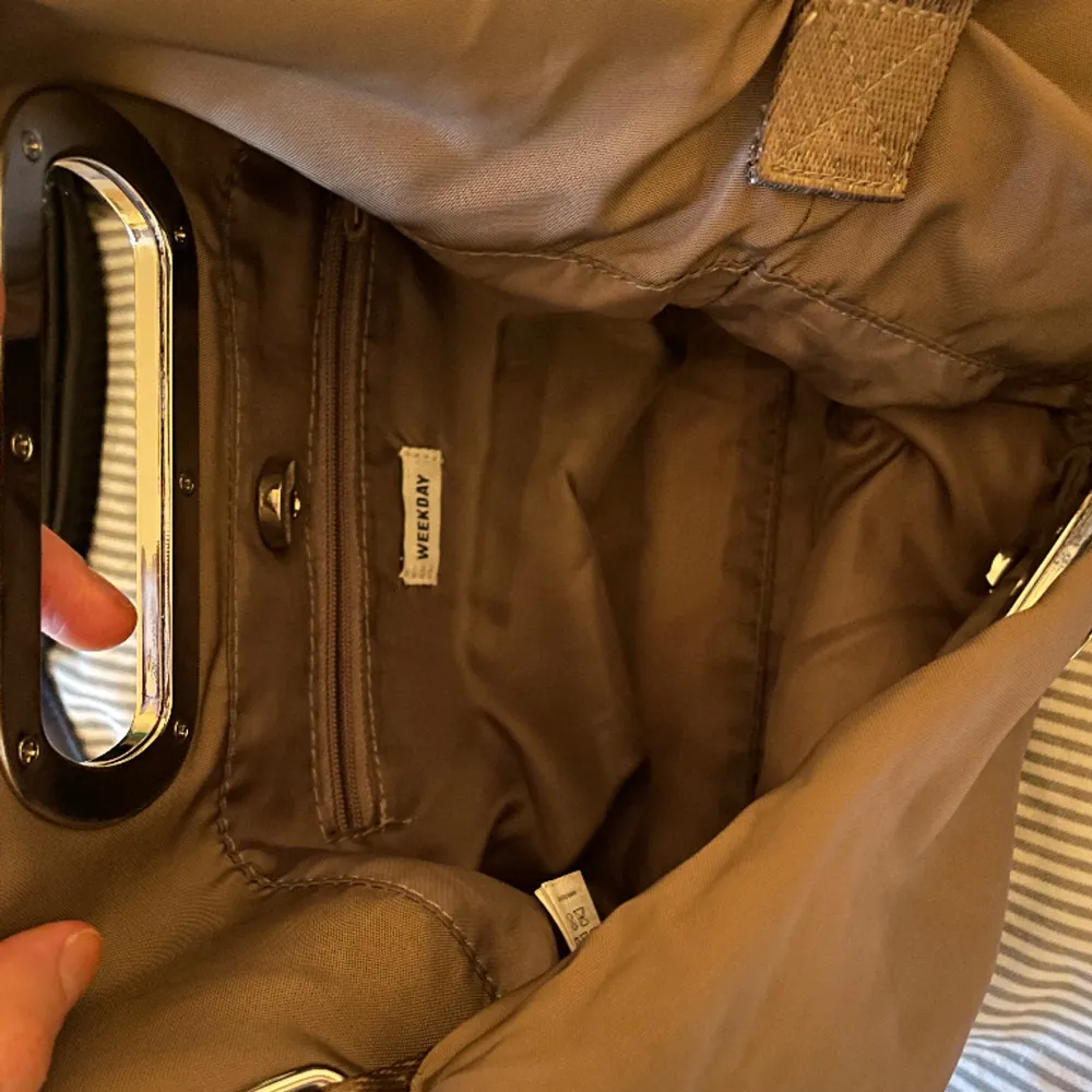 Brun väska från weekday i bra storlek med ett innerfack och silvriga detaljer. . Accessoarer.