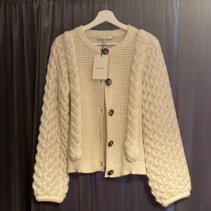 Kofta  - Säljer denna jättefina vita kofta från Gestuz då den inte kommer till användning. Helt oanvänd så den är i toppskick! Storlek s men skulle säga att den passar allt från xs-m. Nypris är 1699 och jag säljer för 599!