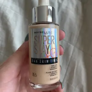 Maybellines skin tint i färg 5,5. Använd några gånger men ca 80 % kvar. Den är tyvärr lite för ljus för mig och har endast droppat ut produkt på borste så har inte nuddat direkt på ansiktet. :)