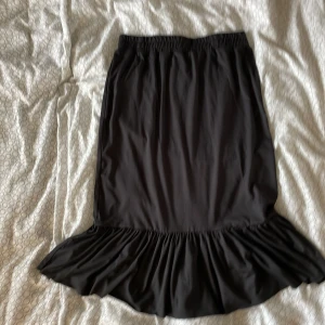 Lång svart kjol - En lång svart kjol med volang i botten 