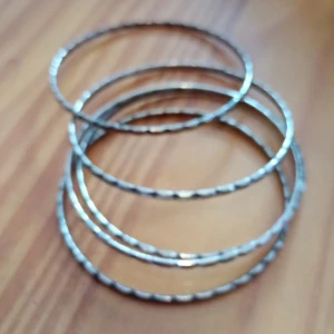 Fem armband silverfärgade mönster. - Fem armband mönstrade silverfärgade.