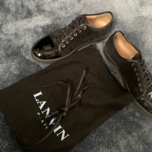 Svarta Lanvins Glans - Säljer ett par asfteta Lanvins i storlek 46. Skicket är 10/10 i princip nya inga defekter. Skorna har glans och box(utan lock) medföljer även med dustbag och kvitto på boxen medföljer. Org pris 4299 Mitt pris 2000 ! Kan sänkas vid snabb affär!🤝 