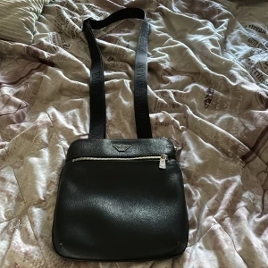 Armani Axelväska - En fin Armani väska i använt skicka, 7/10. Sparsamt använd och fint läder. Justerbart axelband med Armani texten på. Hör av er vid minsta fundering!