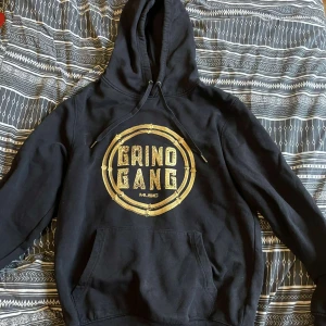  Svart Grind Gang Music Hoodie - Storlek: S Tröjan är i bra skick  Grind Gang Music är ett skivbolag som bl.a har Adaam i skivbolaget. Det är en rare tröja eftersom att dom inte säljs  längre.  Sprickor i loggan. Kan sänka för rätt pris