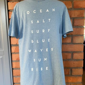 T-shirt herr H&M strl M - 100% Bomull  Ljusblå med vit text 