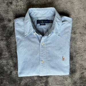 Ralph lauren skjorta - Säljer denna ljusblåa Ralph lauren Oxford skjorta storlek M i utmärkt skick.  Mått finns på bild så jämför med ett av era plagg så vet ni om det passar😊