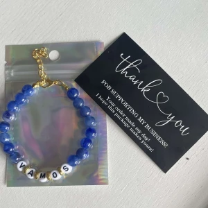 Egengjort pärlarmband  - Egengjort pärlarmband med blåa pärlor. Armbandet har bokstäver som bildar ordet ”vamos”. 