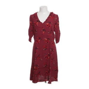 Klänning från Bondelid - Söt, ljuslila klänning med mönster av kaniner och små prickar. Den har en rund halslinning och klädda knappar framtill. Ärmarna är tre fjärdedelslånga och har en volang vid armbågen. Figursydd, dragkedja i  ryggen.  Längd:  strax ovanför knäet. 