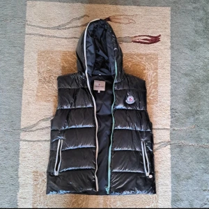Mocler väst - Tjenare! Säljer denna tvär feta moncler västen! Skick: 6/10! Jackan är perfekt inför höst/skolstarten, den är skick 6/10 därför lacken har börjat gå av! Dragkedjan är även sönder men lätt o fixa   Vi hörs!🫡
