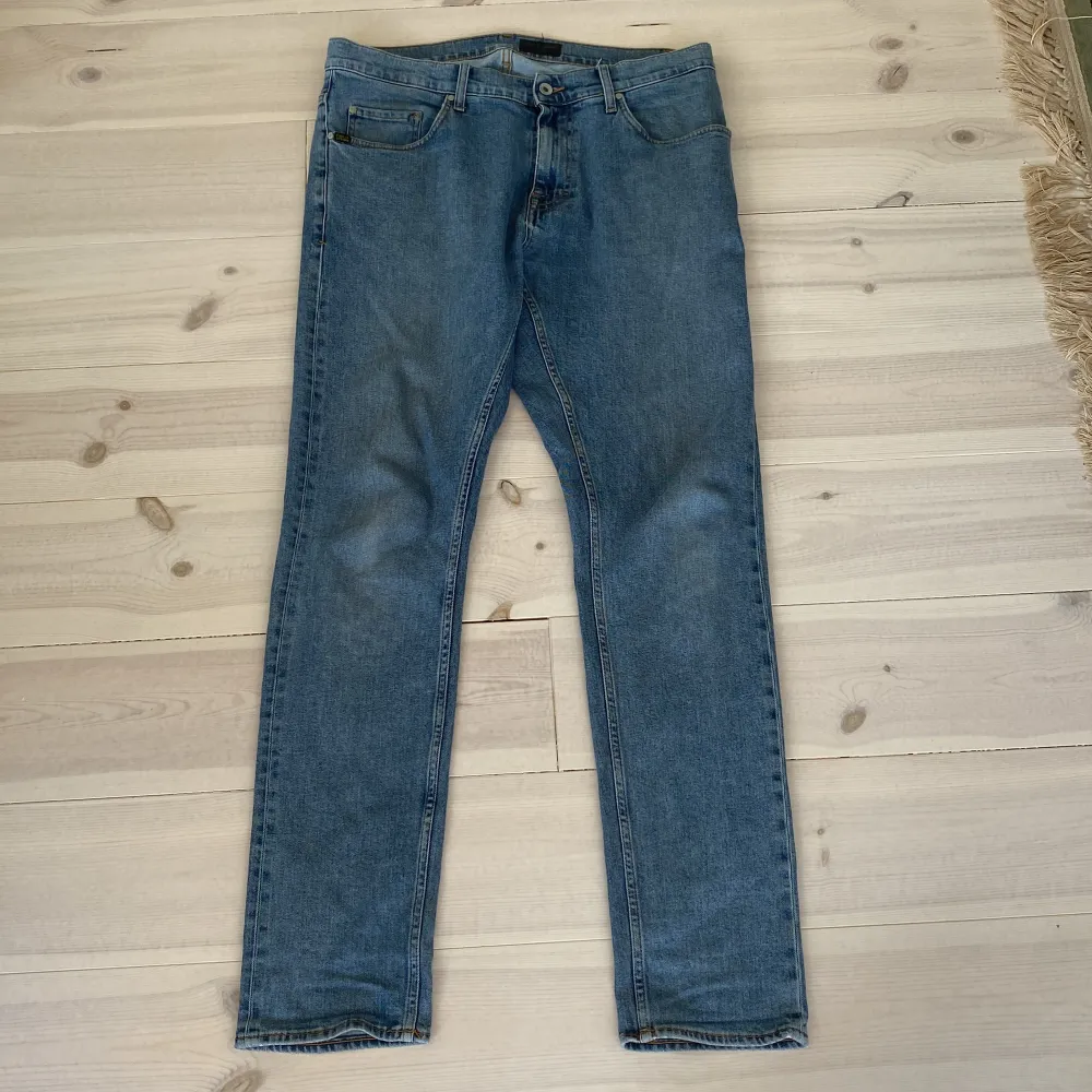 Blåa Tiger of Sweden jeans i storlek 33/34. Litet hål vid bakfickan, se bild 2.. Farkut & Housut.