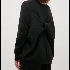 Ljuvlig ylletröja - COS - Ljuvlig ylletröja från COS med en rosett bak och vanlig slät på framsidan.  Färg: Svart Storlek: S, tvättad och något krympt  Skick: Använd i fint skick. 