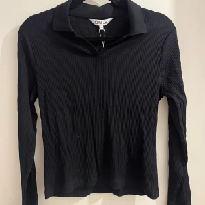 Svart polotröja från ONLY  - Svart polotröja från ONLY. Aldrig använd med prislappen kvar.