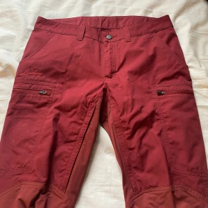 Lundhags byxor - Röda Lundhags byxor, bara använda en gång så dom är i nyskick. Köpte för 1100kr på rea vanligt pris är 2300kr. Säljer för 900kr med inräknad frakt i priset. Inget fel på dom, dom är som nya men vill bara bli av med dom fort därmed det låga priset. 