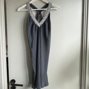 Nattlinne med spets - Superfint och mjukt nattlinne i blågrå med vit spets och korsning i ryggen🖤 Passar stl M-XL beroende på hur man vill att det ska sitta! Knappt använt <3 