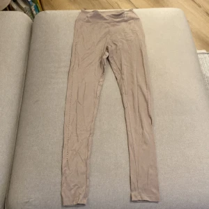 Gymshark tights - Tights från gymshark i beige-rosa med hål längs benen. Väldigt sparsamt använda