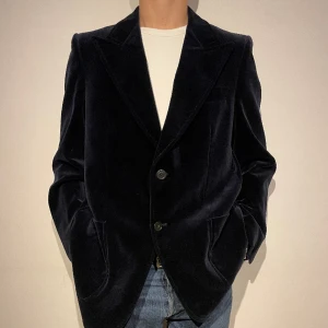 Vintage sammetskavaj - Marinblå kavaj i sammet. Kavaj är riktigt skön och i grymt bra skick. Kavajen kan användas under hela året och är passande till den som vill ha på sig något utöver det vanliga Skriv vid vidare frågor. 