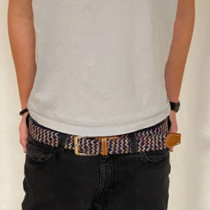 Grisch/Flätat Bälte - Säljer ett grisch/flätat bälte i färgerna brun, guld samt svart. Bältet är i en limiterad upplaga och är väldigt unikt i färgen.  | Skick: 10/10 (aldrig använd).  Hör av er för fler bilder!