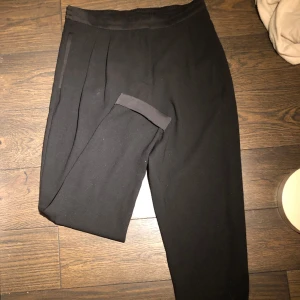 Lågmidjade kostymbyxor - Jätte snygga lågmidjade kostymbyxor med fickor i fram, fake ficka i bak. Står ingen storlek men gissar på 42-Large