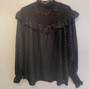 Blus  - Svart blus med guldiga prickar.