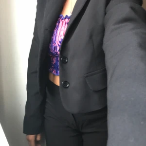 Svart kavaj från Zara - Säljer en snygg svart kavaj/blazer från Zara i storlek S. Kavajen är helt oanvänd och sitter skitsnyggt! Modellen är lite cropped suit style så passar både som jacka och kavaj