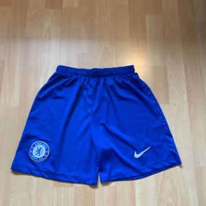 Chelsea shorts - Fotbollsshorts från Chelsea fc i storlek 176 men passar Xs,S. De är knappt använda och är i perfekt skick men pris kan diskuteras.