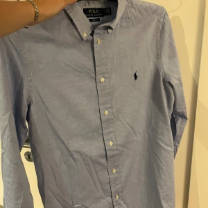 Ralph lauren skjorta  - Säljer denna trendiga Ralph lauren skjorta i riktigt bra skick. I storlek 20 vilket sitter som en S i storlek. Ny pris runt 1200kr mitt pris 400kr. Vid snabb affär kan priset diskuteras. Vid fler frågor är det bara att höra av sig.