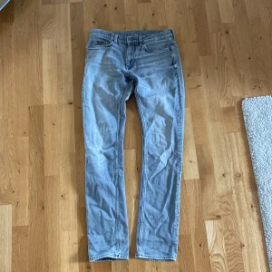 Ljusblå jeans från calvin clein  - Säljer ett par ljusblå jeans från calvin clein. De är i bra skick och har en snygg, sliten look. Jeansen har en dragkedja och knappar framtill, och de är i en straight fit. Perfekta för både vardag och fest!