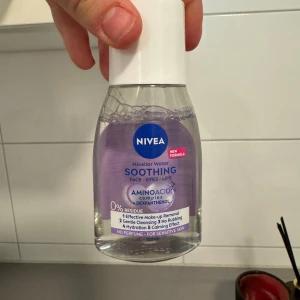 NIVEA Micellar Water Soothing - Säljer en flaska NIVEA Micellar Water Soothing för ansikte, ögon och läppar. Denna micellärvatten är speciellt framtagen för känslig hud och innehåller aminosyror och dexpanthenol för att lugna och återfukta huden. Den är parfymfri och lämnar inga rester. Perfekt för effektiv sminkborttagning och mild rengöring utan att behöva gnugga.