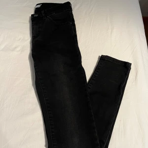 Svarta Wera jeans - Svarta jeans från Wera. Byxorna har en klassisk femficksdesign och är tillverkade i ett slitstarkt material. De har en knapp och dragkedja framtill. Endast använd några gånger, nyskick. Midjemått rakt över: 31.5cm. Innerbenslängd: 73cm