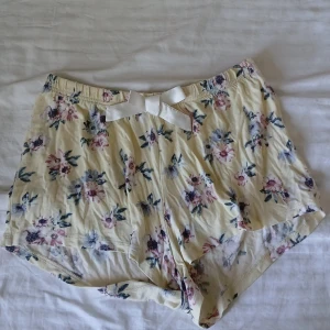 Gula pyjamasshorts med rosett - Gula pyjamasshorts med rosa blommor på. Otroligt stretchiga så passar nog från XS-M/L. Säljer då de blivit för små 💕