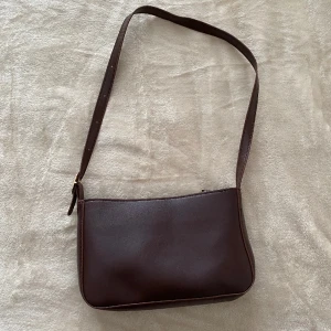 Brun handväska - Liten brun handväska från shein, köpt för 85kr. Bandet går att ändra så du kan ha den kortare eller längre om du vill! Aldrig använd så i nyskick❤️