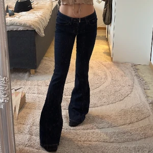 Levis lågmidjade bootcut jeans  - Mörkblå lågmidjade bootcutjeans från Levis 💕 stretchiga! De har ett annat tyg vid benen som är så fin men svår att få med på bild men skriv gärna så fixar jag deeeet💕 midjemått: 71cm Innerbenslängd: 82cm 