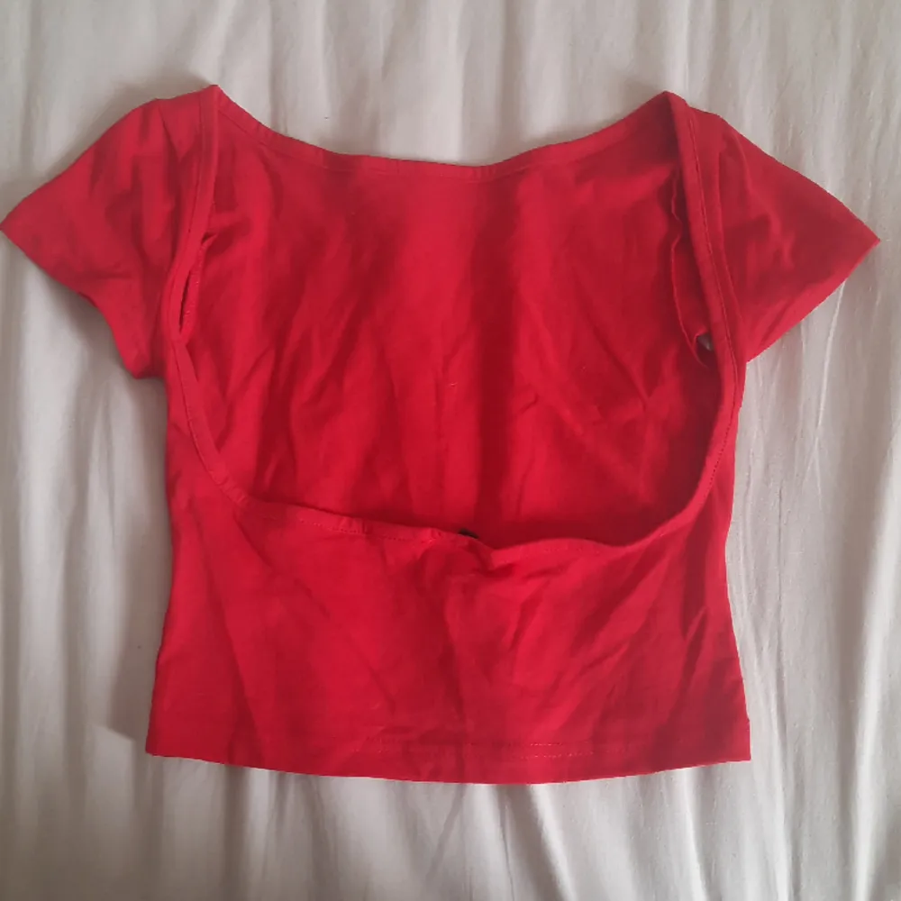 Röd T-shirt med öppen rygg. Köpt från SHEIN. Aldrig använd. Säljer då det är fel storlek för mig. Jag skulle säga att den passar XS och S. T-shirts.