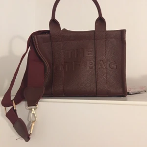 Väska  - En fin väska i läderimitation ett stort fack med dragkedja. Dock är botten inuti väskan lite ful men inget som stör funktion eller utseende på väskan utvändigt så den är väldigt fin i sig . 