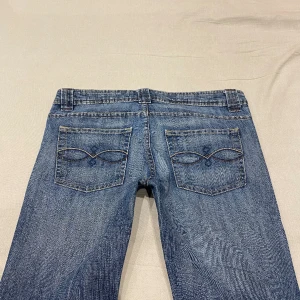 lågmidjade utsvängda jeans med snygga detaljer💕 - midja 44 cm rakt över och innerben 75 cm ja e 170 för referens o de e för korta samt behöver hålla in i midjan :(