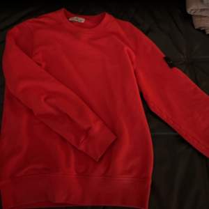 Röd stone island sweatshirt. Kommer inte till användning och använd fåtal gånger.  Skick:10/10 Pris kan diskuteras
