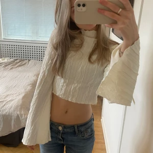 Vit tröja  - Säljer denna jätte snygga vita tröja med fina detaljer i tyget och trumpetärm❣️Använd bara ett fåtal gånger och är i superbra skick!
