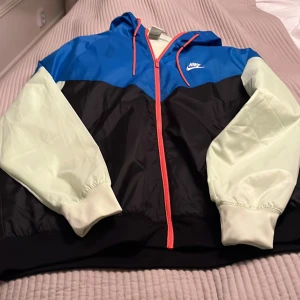 Nike träningsjacka  - Huvtröja , nyskick, oanvänd  Färg : svart, / blå /gul  orange dragkedja  Köpt i Zalanndo   