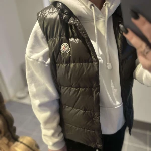 Moncler väst - Fin mörkbrun Moncler väst perfekt till våren. Den är storlek 2 men passar som en XS/S. Passar bra på mig som vanligtvis har XS och är 158cm lång. Inga slitningar eller hål, mycket fint skick.